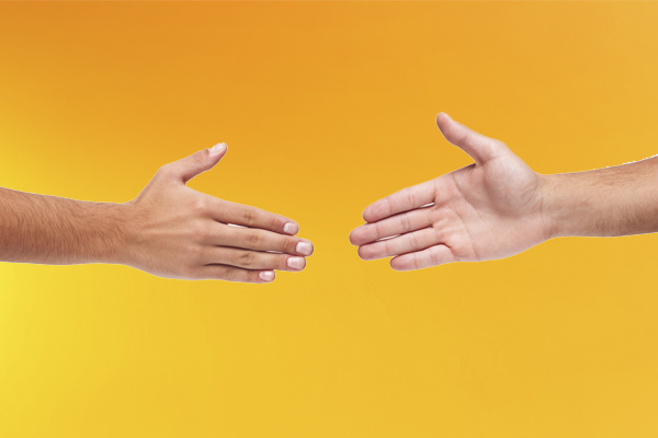 Two hands moving toward each other preparing for a hand shake, representing counselling therapist and client agreement.